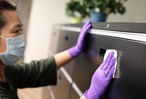 Woman wearing gloves cleaning locker